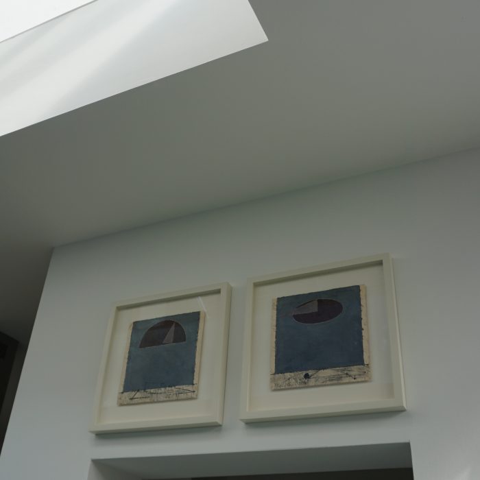 2 white framed paintings on a wall