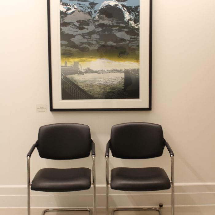A stormy sky painting and 2 chairs