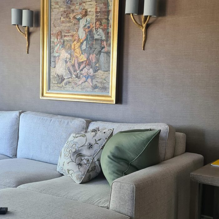 A grey sofa with a painting above